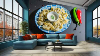 dumplings in a blue plate and two hot chili peppers top view Wall mural