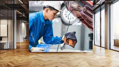 Asian man automobile mechanic checking oil level in the car engine at auto garage shop. after repair service concept Wall mural