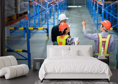 Group of warehouse workers walking and checking on stock before shipping delivery in the factory. Staff with client visiting at distribution center. Logistic business career. Wall mural