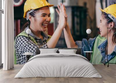 happy cheerful female engineer or industrial technician worker giving high five to colleagues after  Wall mural