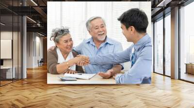 Happy smiling Asian old couple making purchase and mature woman handshake with real estate agent, Sales man closing deal from business agreement contract, concept for retirement or lifestyle insurance Wall mural