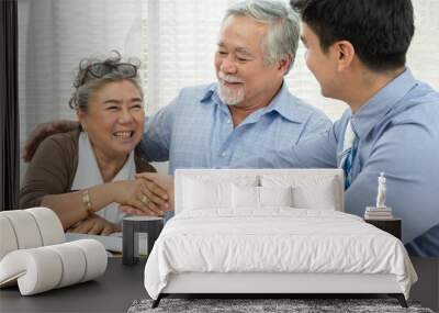 Happy smiling Asian retired senior couple making purchase and mature woman handshake with real estate agent, Sales man closing deal from business agreement contract, Healthy living and insurance Wall mural