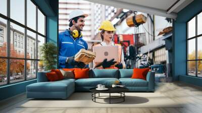 Male and female industrial worker or engineers in hard helmet discuss project while using laptop. Man and woman technician people working in heavy technology invention industry manufacturing factory.  Wall mural