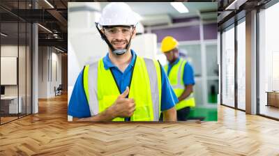 Portrait of confident male engineer foreman in safety helmet smile showing thumbs up in front of factory production. man operating machine at industrial plant. men at work concept. Wall mural