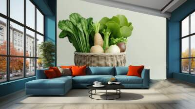 A fresh assortment of green vegetables in a wicker basket, perfect for showcasing healthy eating and organic farming. Wall mural