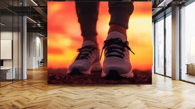 Close-up of a person wearing athletic shoes against a stunning sunset, symbolizing fitness, movement, and a healthy lifestyle. Wall mural