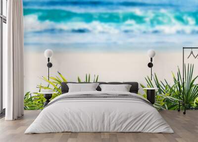 defocused tropical sand beach with blurred water wave and fresh green palm leaves in forground, beautiful nature background concept with copy space for travel relaxation vacation Wall mural