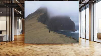 A hiker walking in Faroe Wall mural