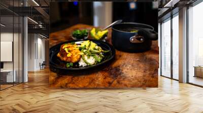 a pan and two plates with food on a table near a bowl Wall mural