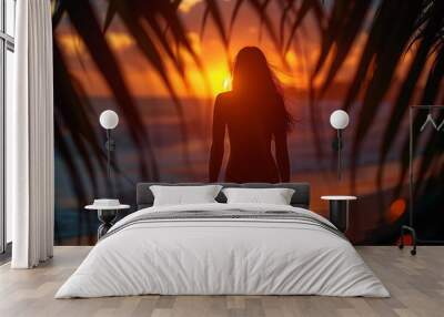 a woman in a swimsuit stands on the beach at sunset Wall mural