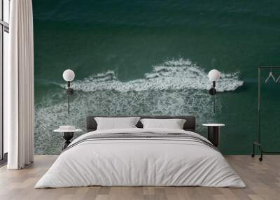 Aerial of sea tidal waves coming towards the shore on a sunny day Wall mural