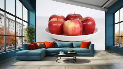 AI generated illustration of a plate of bright, red apples resting on a white plate Wall mural