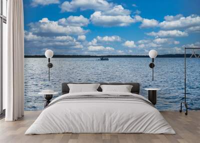 boats in the open ocean under cloudy skies on a sunny day Wall mural