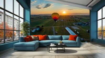 Colorful hot air balloon floating above a rural area in Pennsylvania at sunrise Wall mural