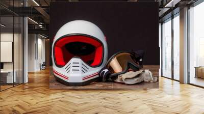 Closeup of a helmet, goggles, and gloves on a table. Wall mural