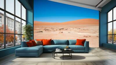 Dried-up water pan in the desert surrounded by sand dunes. Wall mural