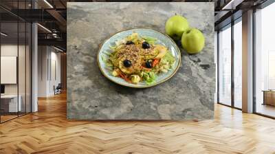 Fresh salad with apples and olives on rustic plate. Wall mural