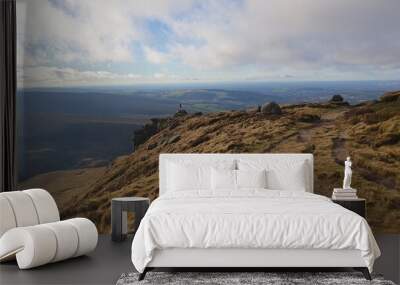 grassy hill top with two small stone piles and a view into the countryside Wall mural