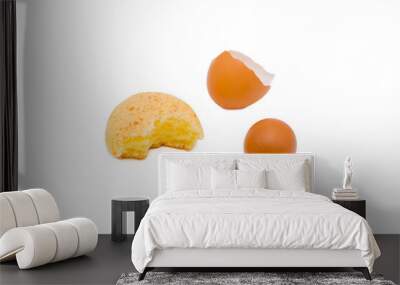 Half-eaten cookie beside two eggs on a white surface Wall mural