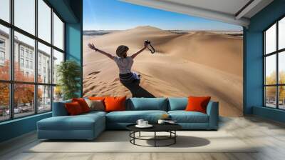 Lone women traveling in a desert with sand dunes and a clear blue sky in Namibia, Africa Wall mural