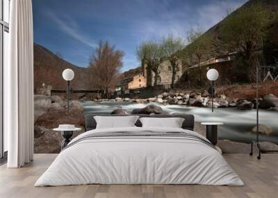 Low-angle of a sunlit mountain river, yellow grass and stones around Wall mural