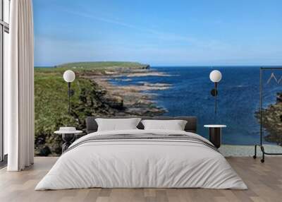 Rocky coastline with clear blue water and bright sky Wall mural