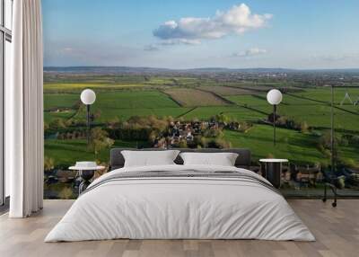 Scenic countryside landscape with lush green fields in the foreground Wall mural