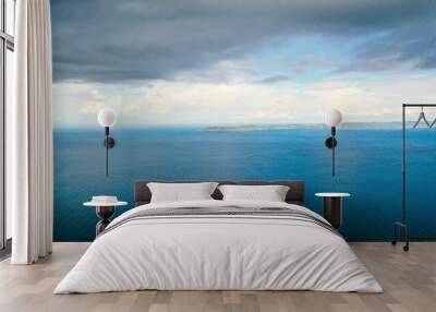 Scenic view of dark cloudy sky over clear blue endless ocean Wall mural