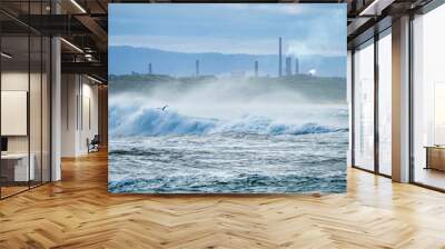 Skyline with ocean waves crashing and a bird flying over the water Wall mural