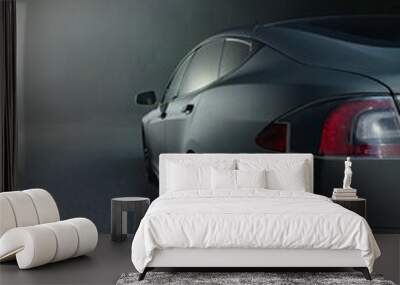 Sleek black car on a foggy night with a bright light in the background Wall mural