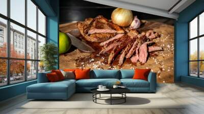 Sliced grilled steak with knife and vegetables on wooden board Wall mural