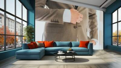 Young professional man wearing a stylish suit in a modern interior with a white wall Wall mural