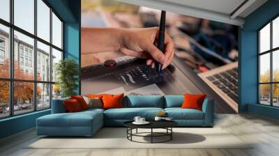 Young woman drawing on a digital tablet. Female graphic designer working from home Wall mural