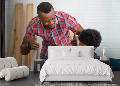 African black male carpenter man father teach boy kid child son to be carpenter drilling wood in carpentry workshop. Concept hobby at home. Wall mural