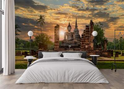 Buddha statue and pagoda Wat Mahathat temple with dramatic syk sunset, Sukhothai Historical Park, Thailand Wall mural