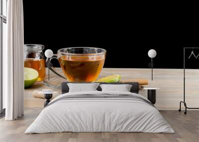 Early morning tea cups with lemon and honey resting on an old wooden table on a black background Wall mural