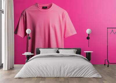 A vibrant pink t-shirt displayed against a matching pink background, ideal for fashion and apparel promotion. Wall mural