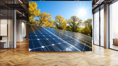 Bright sun shining over solar panels surrounded by colorful autumn trees, showcasing renewable energy in a vibrant landscape. Wall mural