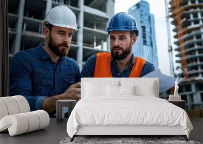 Two construction workers in hard hats review blueprints at a construction site, surrounded by cranes and tall buildings under construction. Wall mural