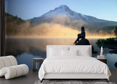 traveler sitting on rock and looking over scenic Mount Hood view with sunrise at Trillium Lake, Oregon Wall mural