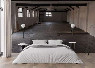 The inside of an empty farm building with white walls and black beams Wall mural