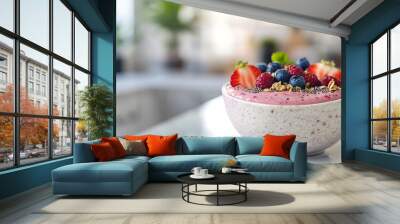 Close up of a pink smoothie bowl topped with raspberries, blueberries, strawberries and granola. Wall mural