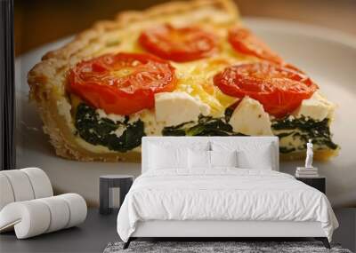 Close up of a slice of spinach and feta cheese quiche with tomatoes on a white plate. Wall mural