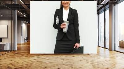 business woman with siutcase and coffee standing by white wall m Wall mural