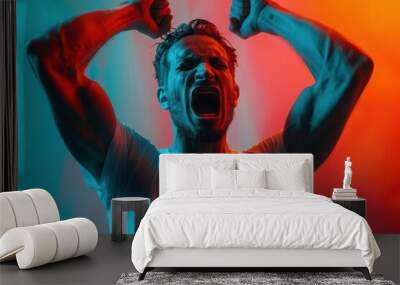 A man in a white t-shirt screams in triumph, illuminated by vibrant red and blue light. Wall mural