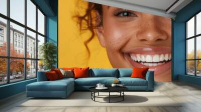 A smiling woman with curly hair against a vibrant yellow background, exuding joy and positivity. Wall mural