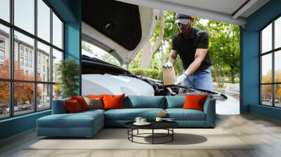 A technician examines a car engine in a garage, focusing on battery and electrical components. The close-up scene emphasizes quality control, maintenance, and automotive expertise. Wall mural