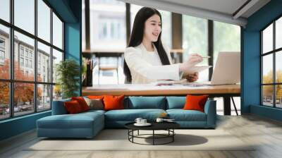 Asian businesswoman working with laptop in office Wall mural