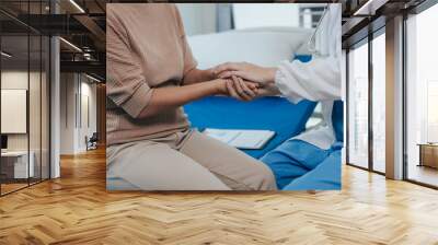 Young female doctor nurse caregiver caring happy senior grandmother helping old patients in rehabilitation at elderly health checkup Wall mural