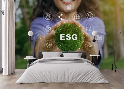 ESG icon concept in the woman hand for environmental, social, and governance by using technology of renewable resources to reduce pollution and carbon emission . Wall mural